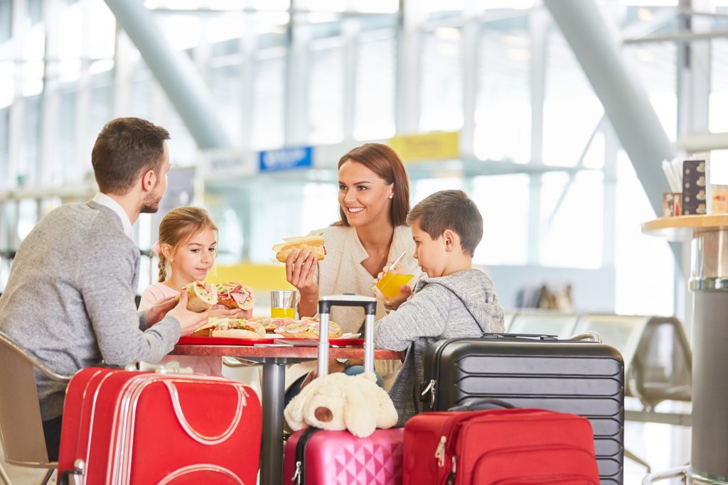 Family,With,Children,Eating,In,Restaurant,Before,Leaving,Airport,Or